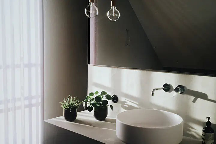 Kleine Kunstpflanzen im Badezimmer einer Ferienwohnung.